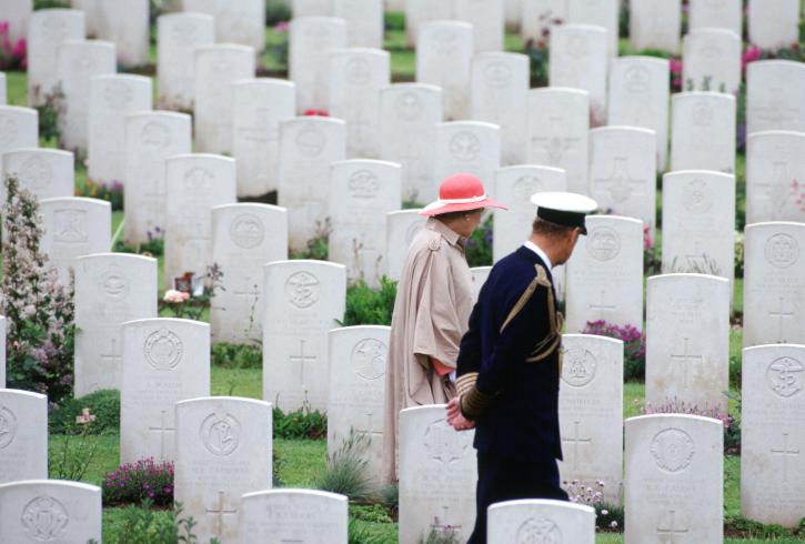 La reine Elizabeth II et son époux au milieu des tombes d'un cimetière du Commonwealth