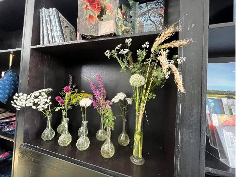Rangée de soliflores avec des fleurs dans un étagère à l'accueil du site