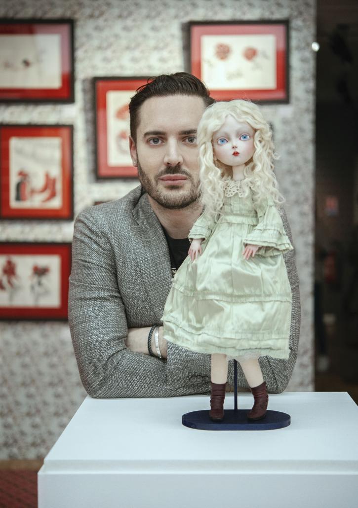 Portrait de Benjamin Lacombe dans l'exposition, au premier plan une figurine d'Alice