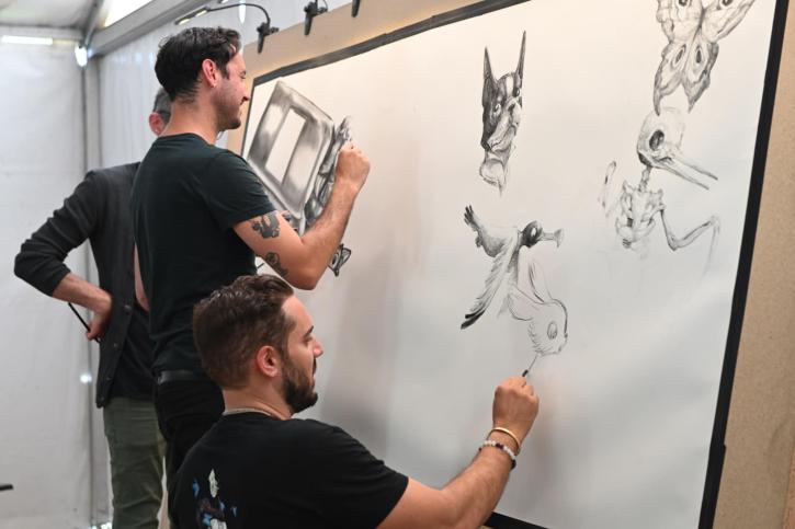 Les trois illustrateurs dessinent une fresque grand format