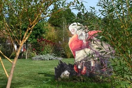 Personnage d'Alice dans les jardins avec le hérisson à ses pieds