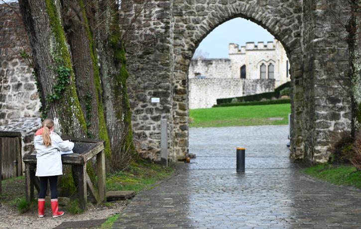 enfant devant l'entrée du château au remparts