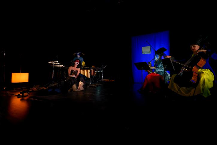 chanteurs et comédiens sur scène dans des lueurs très vives et sombres à la fois